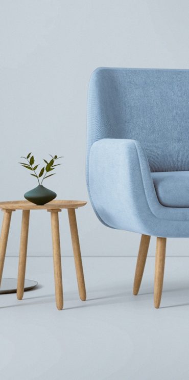 Hellblaue Couch mit Holzbeinen und kleiner Pflanze auf einem Holztisch daneben.