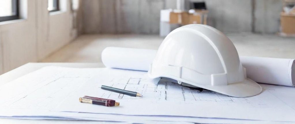 Rote und gelbe Malerwerkzeuge auf einer grauen, strukturierten Oberfläche.