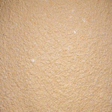 Texturierte, beige Wandoberfläche mit leicht unregelmäßiger Struktur.